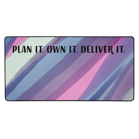 Colorful abstract desk mat with the quote 'Plan It. Own It. Deliver It.' in bold lettering, designed for women project consultants and entrepreneurs