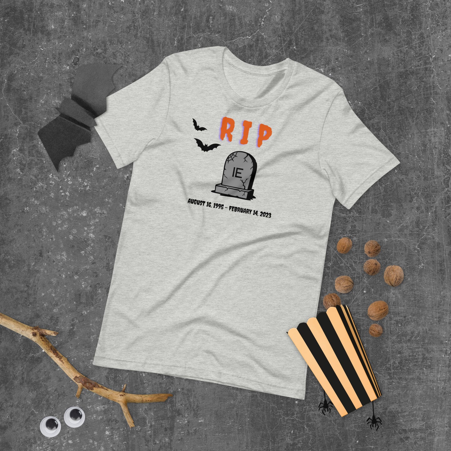 A Halloween T-Shirt for Sysadmins that shows a picture of a tombstone with the letters IE on it and the title RIP and the date Internet Explorer premiered and the date that it was disabled.