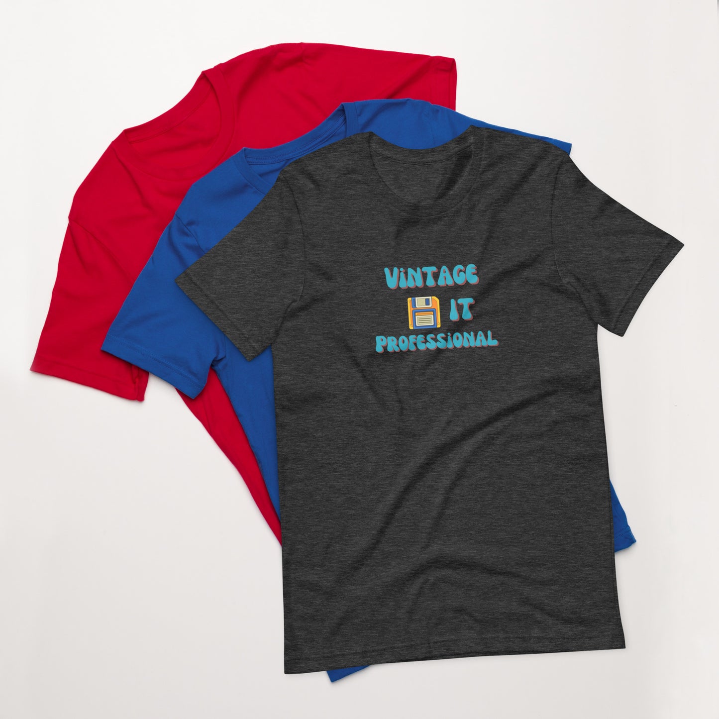 A stack of t-shirts with a heather gray one on top that says Vintage IT Professional and has a picture of a diskette on it.