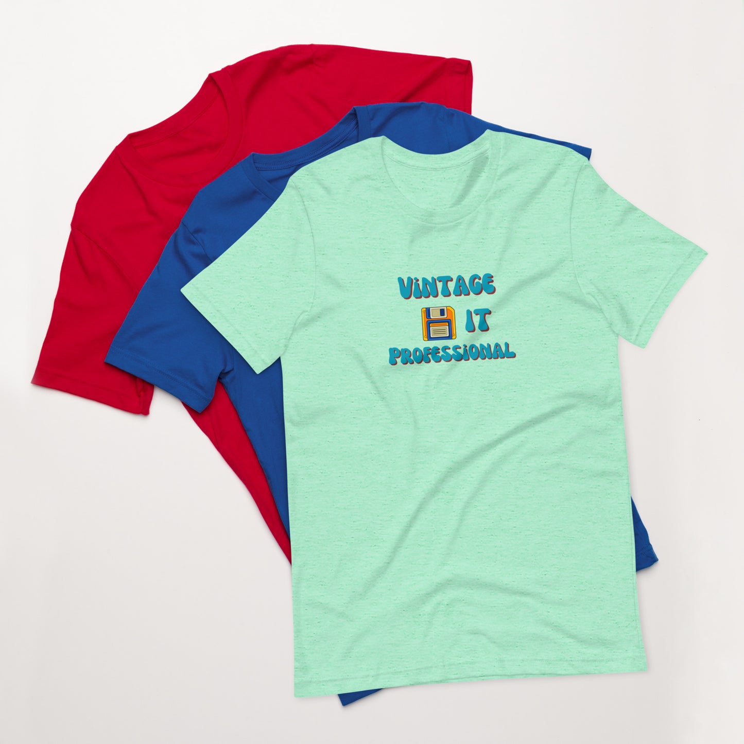 A stack of t-shirts with a mint green one on top that says Vintage IT Professional and has a picture of a diskette on it.