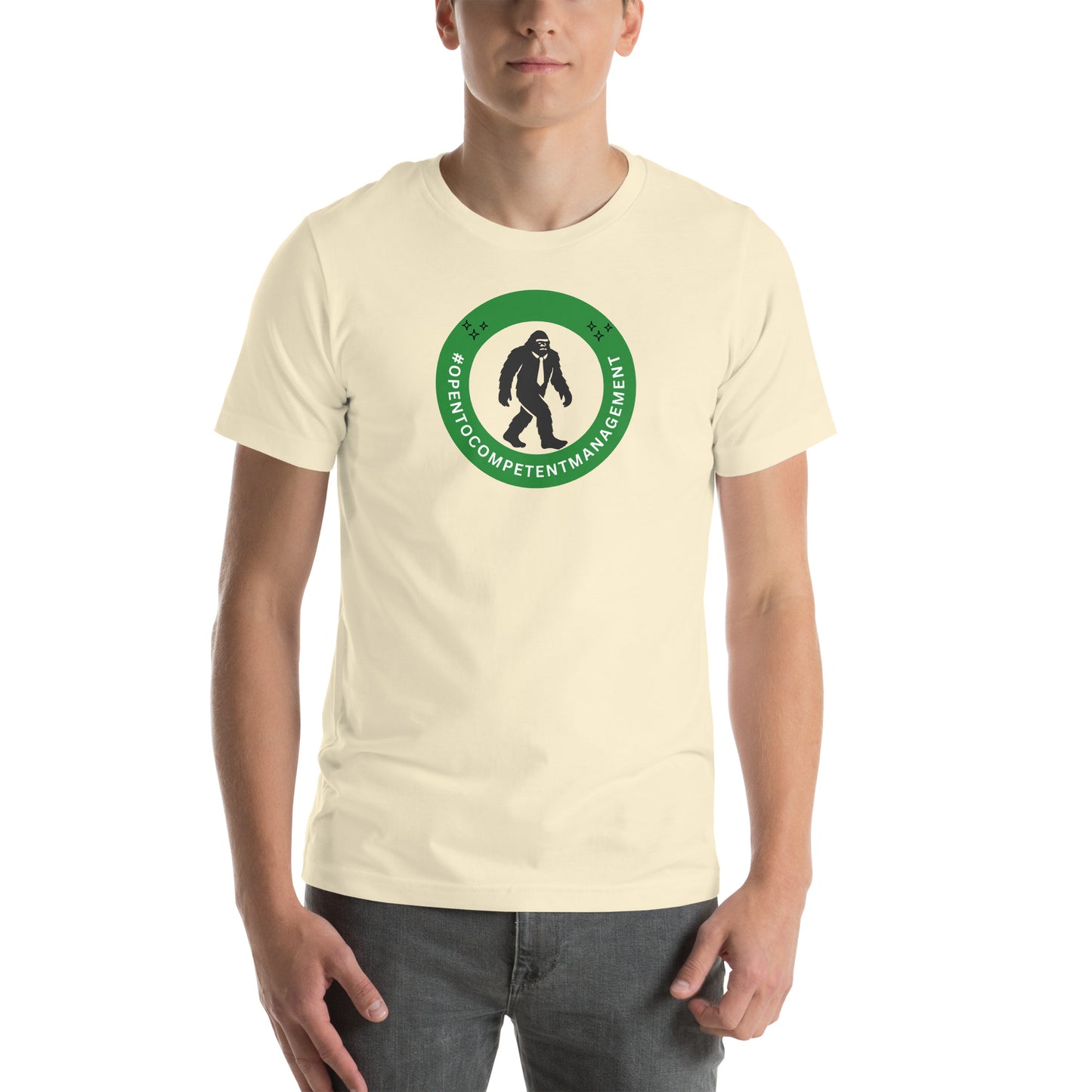 A t-shirt that shows a work status  badge that says #OpenToCompetentManagement with a picture of a bigfoot in a tie.