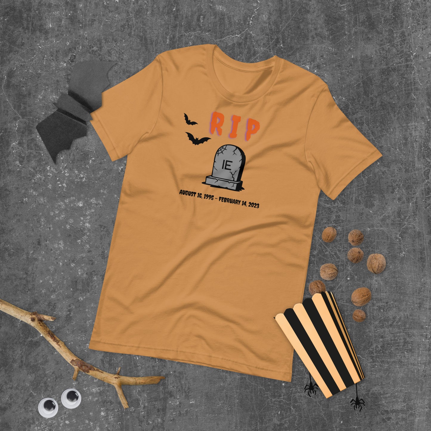 A Halloween T-Shirt for Sysadmins that shows a picture of a tombstone with the letters IE on it and the title RIP and the date Internet Explorer premiered and the date that it was disabled.