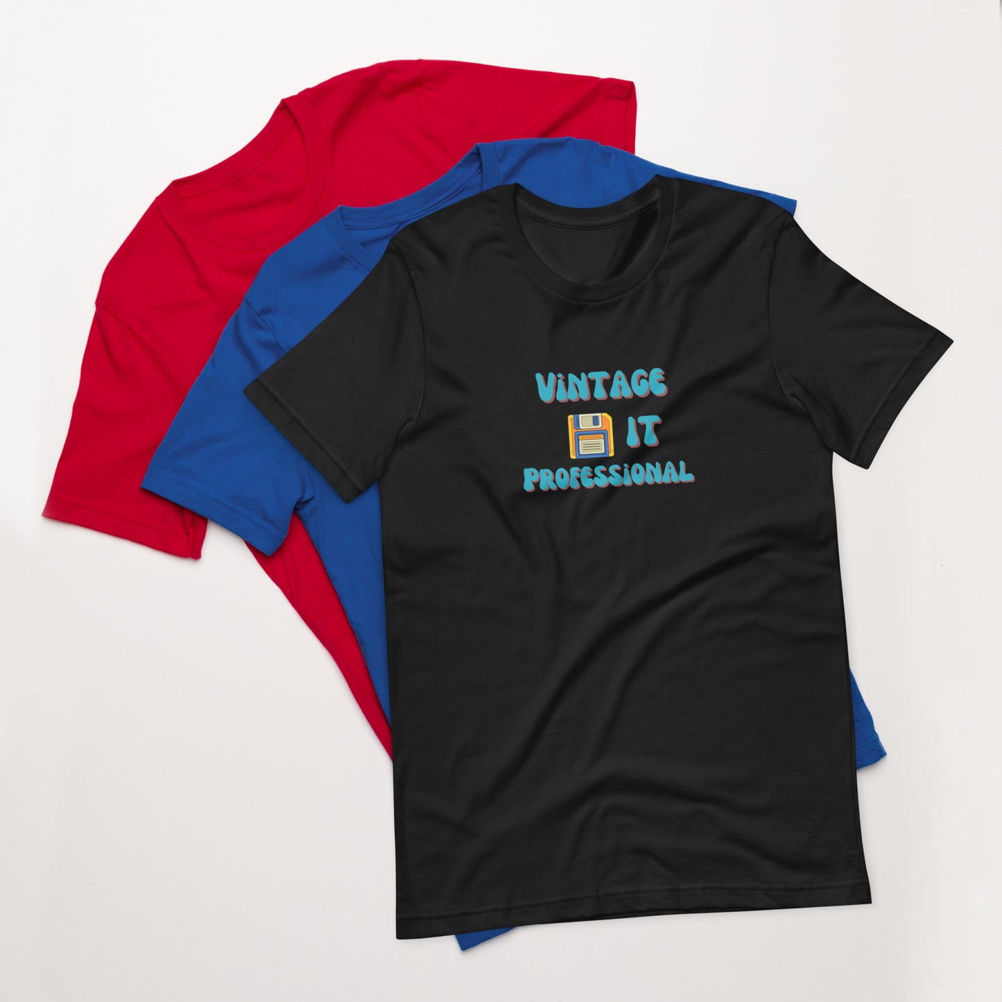 A stack of t-shirts with a black one on top that says Vintage IT Professional and has a picture of a diskette on it.