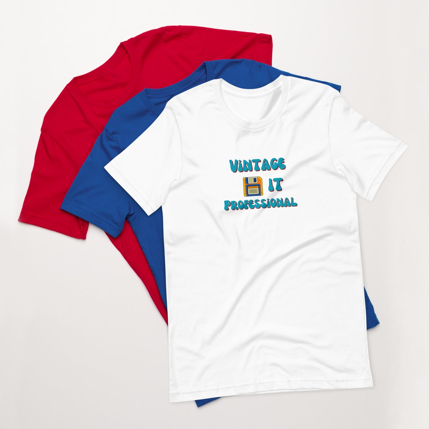 A stack of t-shirts with a white one on top that says Vintage IT Professional and has a picture of a diskette on it.