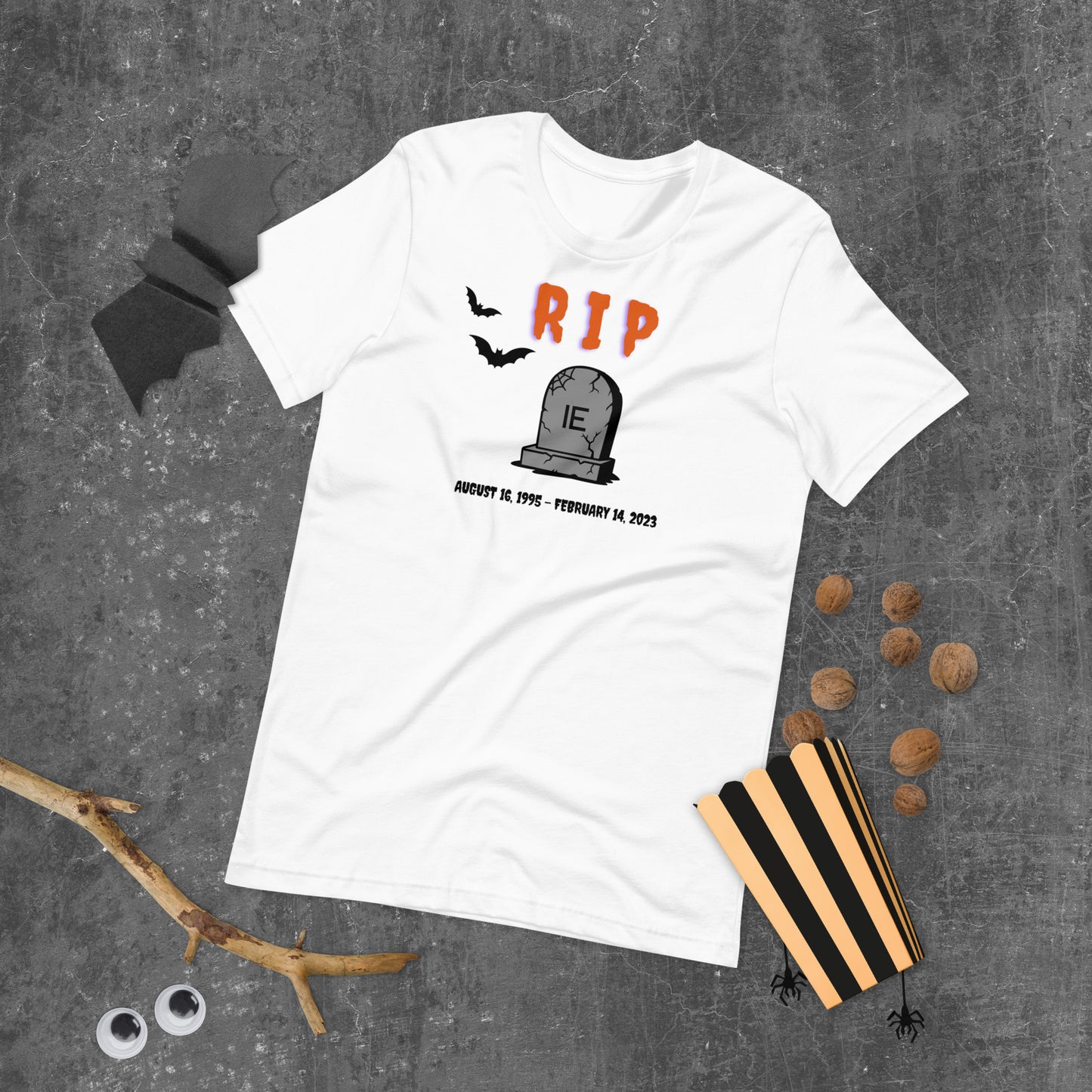 A Halloween T-Shirt for Sysadmins that shows a picture of a tombstone with the letters IE on it and the title RIP and the date Internet Explorer premiered and the date that it was disabled.