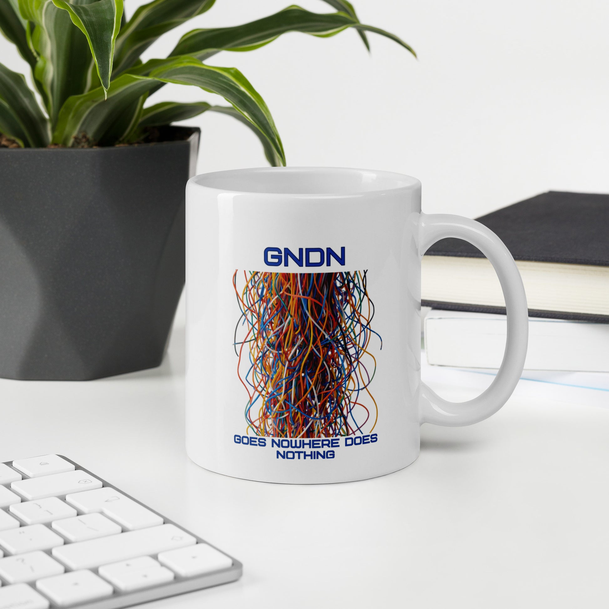 A white mug with a bunch of colorful ethernet cables that go no where and the words GNDN:  Goes Nowhere Does Nothing